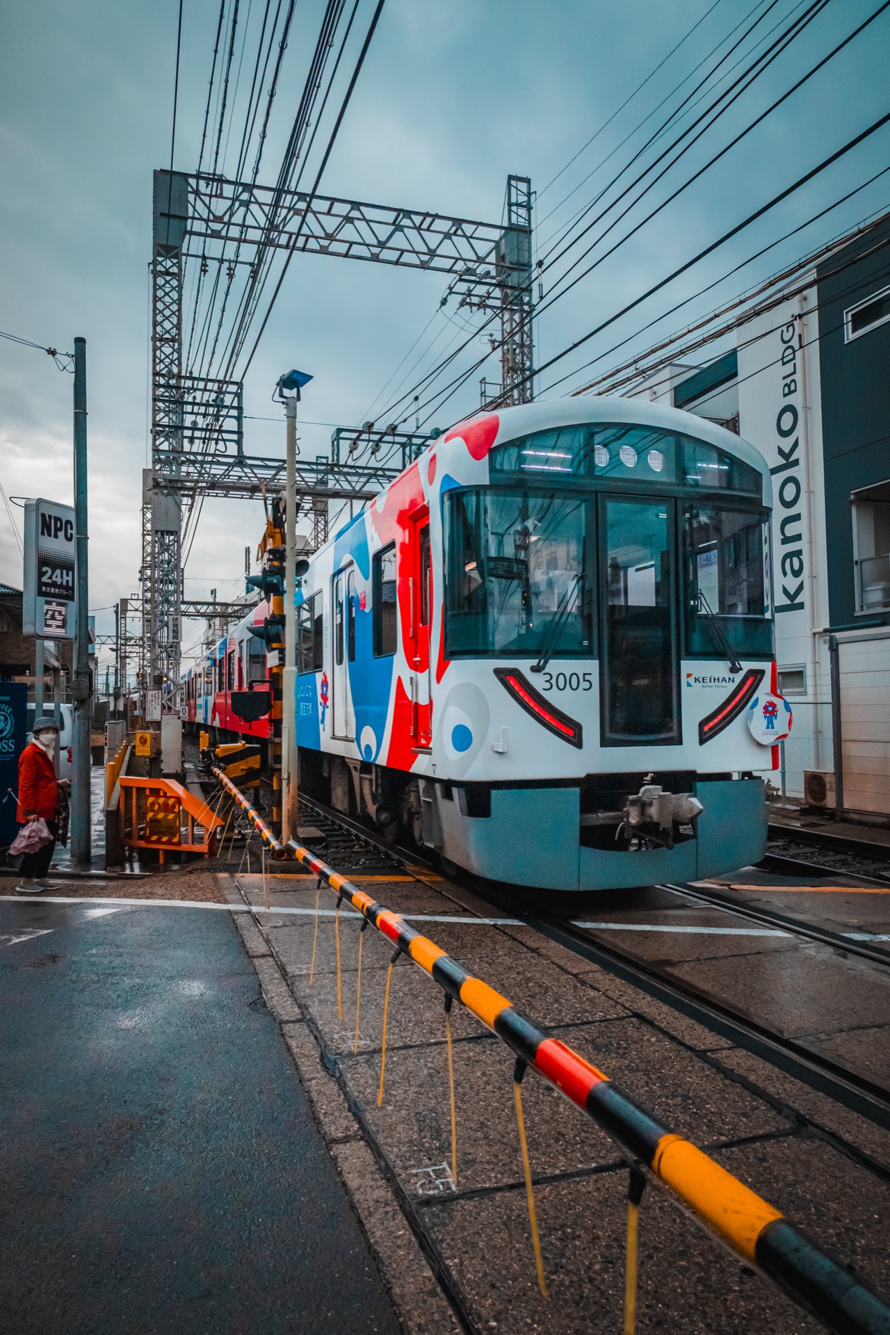 Colourful Kanoko tram at a level crossing